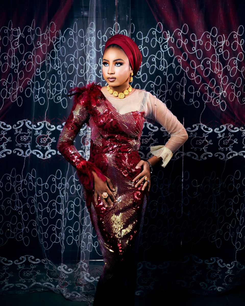 Woman in a long red-burgundy sequin column gown indoors